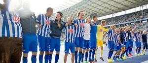 Die Hertha-Spieler hüpfen auf der Laufbahn vor der Fankurve.