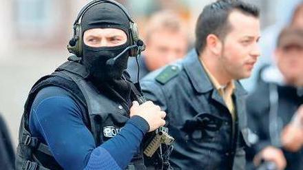 Spezialkommandos bereiten sich vor dem Alten Rathaus auf ihren Einsatz vor. Fotos: Reuters (1)/dpa (2)