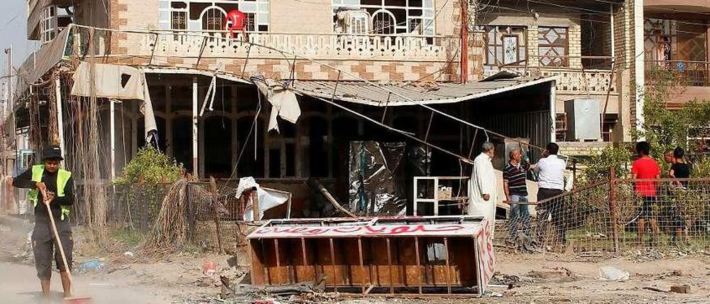 Ein Straßenarbeiter beseitigt die Spuren einer Autobombe in Bagdad. Immer wieder erschüttern Anschläge das Land.