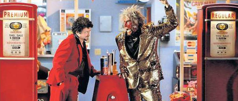 White Trash am Grünen Hügel. Norbert Ernst als Feuergott Loge trifft Mime (in einer Paraderolle: Burkhard Ulrich) an der Tankstelle.