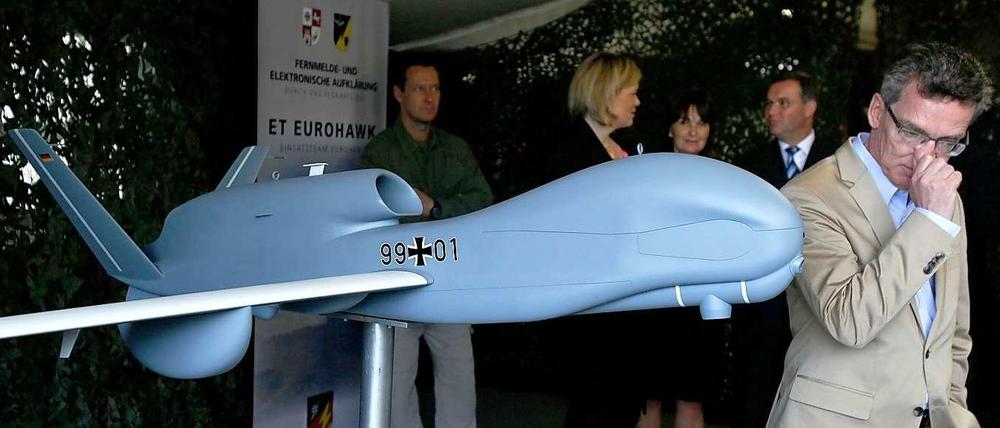 Thomas de Maizière und ein Modell der Euro-Hawk-Drohne.