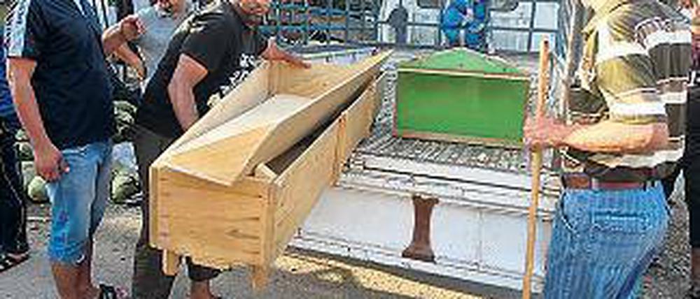 Schrecklicher Alltag. Kaum ein Tag im Irak vergeht ohne Terroranschlag. Menschen verladen die Särge der Opfer einer Bombenserie in Bagdad, bei der mehr als 70 Menschen starben. Foto: AFP