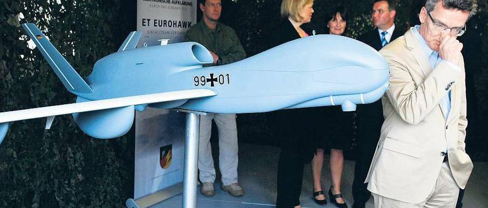 Wichtige Informationen über die Probleme beim Euro Hawk nicht bekommen? Verteidigungsminister de Maizière 2011 vor einem Modell der Drohne. Foto: Wolfgang Rattay/Reuters