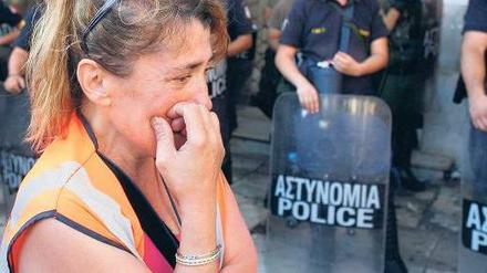 Tränen vor dem Innenministerium. Eine Mitarbeiterin des öffentlichen Dienstes demonstriert in Athen gegen Entlassungen und Sparpläne. 