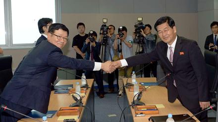 Man zeigt sich versöhnlich: Der südkoreanische Delegationsleiter Suh Ho und der nordkoreanische Chul-su schütteln sich am Mittwoch die Hände. Sie wollen die Gespräche zum gemeinsamen Industriepark wieder aufnehmen.