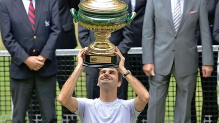 Roger Federer hält den Siegerpokal hoch.