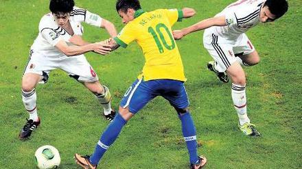 Gezerre um Neymar. Die beiden Japaner Atsuto Uchida (links) und Makoto Hasebe bearbeiten den brasilianischen Wunderknaben. 