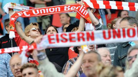 Union-Fans halten ihre Schals hoch.