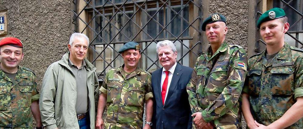 Bundespräsident Joachim Gauck besucht die vom Elbehochwasser betroffene Stadt Meißen in Begleitung des sächsischen Ministerpräsidenten Stanislaw Tillich (CDU, 2.v.l.) und lässt sich mit deutschen und niederländischen Soldaten fotografieren, die sich im Einsatz gegen das Hochwasser befinden.