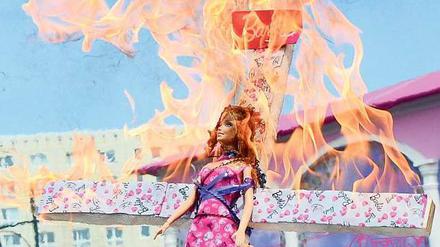 Gegner der vollbusigen Puppe nutzten die Eröffnung des Barbie-Hauses für flammenden Protest.