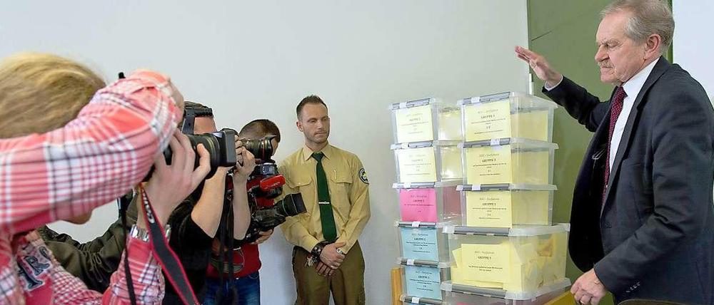 Der Chef des OLG München, Karl Huber, präsentiert die Losbehälter für die Vergabe der Presseplätze beim NSU-Prozess.