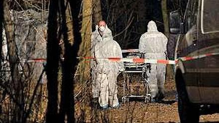 Gerichtsmediziner transportieren den Babyleichnam in einem Waldstück in Hellersdorf ab. Es wurde von einer Spaziergängerin entdeckt.