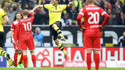 Sahin jubelt, Schahin schaut zu: Während Dortmunds Nuri Sahin seinen Führungstreffer bejubelt, ist Düsseldorfs Danny Schahin (vorne) konsterniert wie seine Mitspieler.
