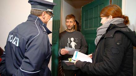 Ein Polizeibeamter und eine Polizeischülerin informieren einen Anwohner in Prenzlauer Berg, wie er seine Wohnung einbruchsicher machen kann.