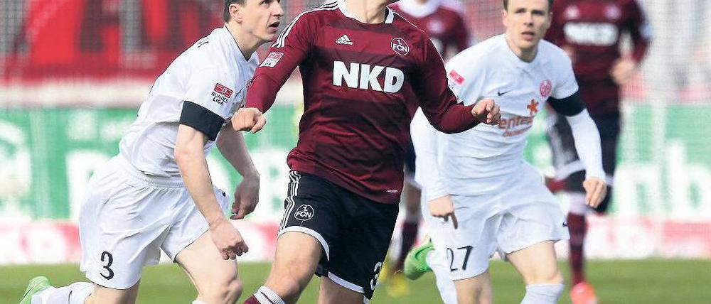 Vorsprung Nürnberg. Esswein (M.) läuft den Mainzern Pospech und Müller weg. Foto: dpa