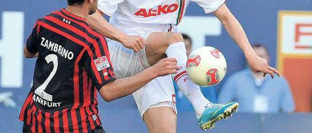 Sprungball. Augsburgs Dong-Wong Ji überzeugt in dieser Szene gegen Frankfurts Carlos Zambrano auf jeden Fall durch bessere Athletik und größeren Einsatz. Foto: dpa
