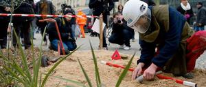 Mit einem Metalldetektor, einer Sonde und einer kleinen Schaufel sucht Olaf Kiesewetter vor dem Brandenburger Tor nach Landminen - allerdings nur nach Attrappen.