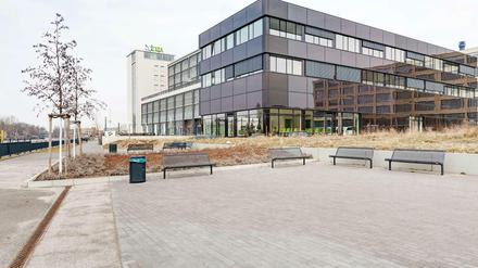 Energiegeladen. In die dunkle Glashülle des neuen Zentrums sind eine Photovoltaikanlage und eine Medienfassade integriert.