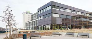 Energiegeladen. In die dunkle Glashülle des neuen Zentrums sind eine Photovoltaikanlage und eine Medienfassade integriert.