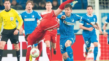 Bahn frei. Hoffenheims Torschütze Roberto Firmino (2.v.r) räumt Robert Tesche aus dem Weg und schickt Düsseldorf in den Abstiegskampf. Foto: dpa