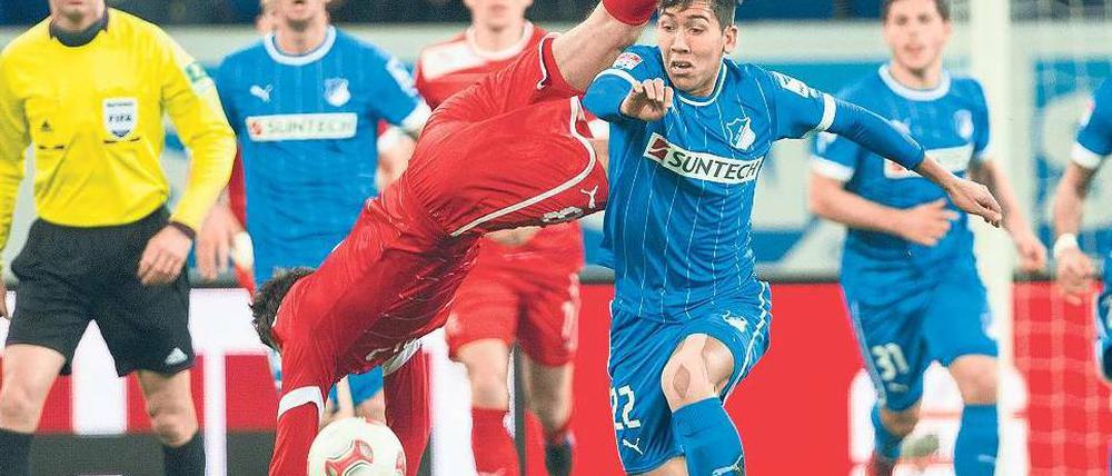 Bahn frei. Hoffenheims Torschütze Roberto Firmino (2.v.r) räumt Robert Tesche aus dem Weg und schickt Düsseldorf in den Abstiegskampf. Foto: dpa