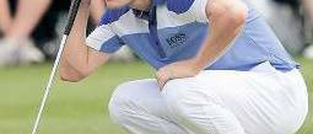 Versunken im Grün. Martin Kaymer visualisiert die Puttlinie.Foto: dpa