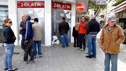 Zyprische Bankkunden stehen an einer geschlossenen Bank an. Es ist unklar, wie es weitergeht auf der Insel. 