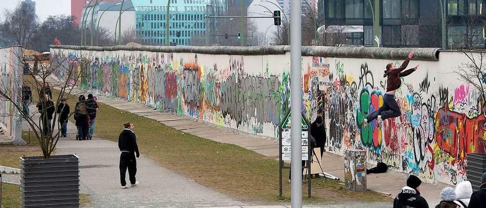 Immer an der Wand lang. Touristen und Berliner flanieren an der West-Seite der East-Side-Gallery entlang. 