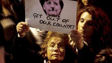 Bei einer Demonstration in Nikosia wird ein Bild von Bundeskanzlerin Angela Merkel mit angemaltem Hitlerbart in die Höhe gehoben.