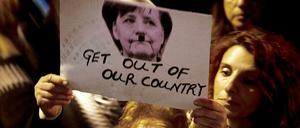 Bei einer Demonstration in Nikosia wird ein Bild von Bundeskanzlerin Angela Merkel mit angemaltem Hitlerbart in die Höhe gehoben. 