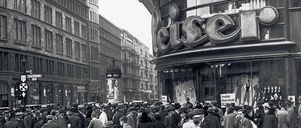 Menschenauflauf während des Boykotts am Tauentzien in Berlin vor dem Schuhhaus Leiser, dessen Eigentümer jüdisch war. Im Fenster hängen Plakate „Kauft nicht bei Juden“. 