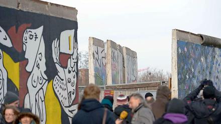 Demonstranten haben sich vor der East Side Gallery eingefunden. In einer Nacht und Nebel-Aktion wurden die umstrittenen Bauarbeiten am Mittwochmorgen fortgesetzt. Eine sechs Meter breite Lücke klafft nun zwischen den Mauerstücken. 