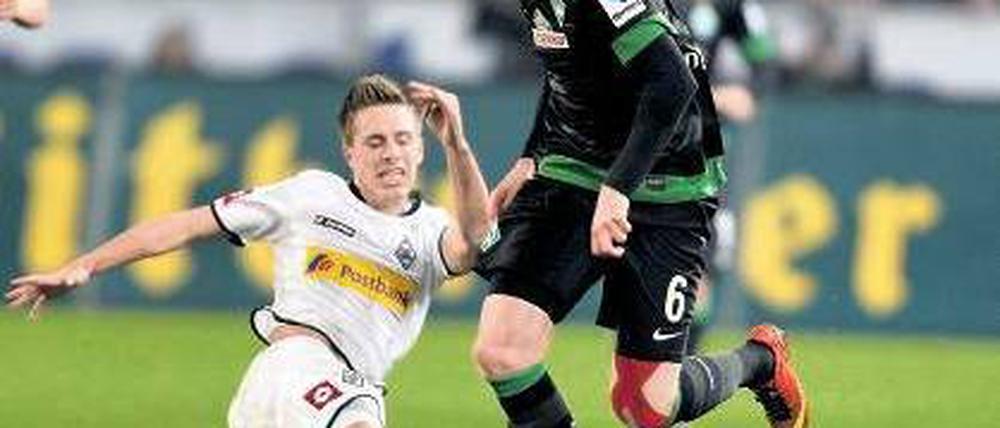Langes Bein muss auch mal sein. Mönchengladbachs Patrick Hermann (links) im Duell mit Bremens Kevin De Bruyne. Foto: dpa