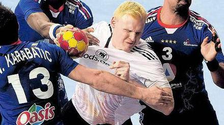 Platz da! Kreisläufer Patrick Wiencek setzt sich gegen drei Franzosen durch. Foto: AFP