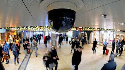 Passanten laufen am 18.12.2012 unter einer Überwachungskamera am Kölner Hauptbahnhof.