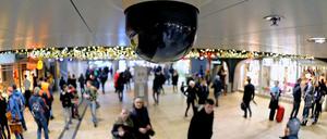 Passanten laufen am 18.12.2012 unter einer Überwachungskamera am Kölner Hauptbahnhof.
