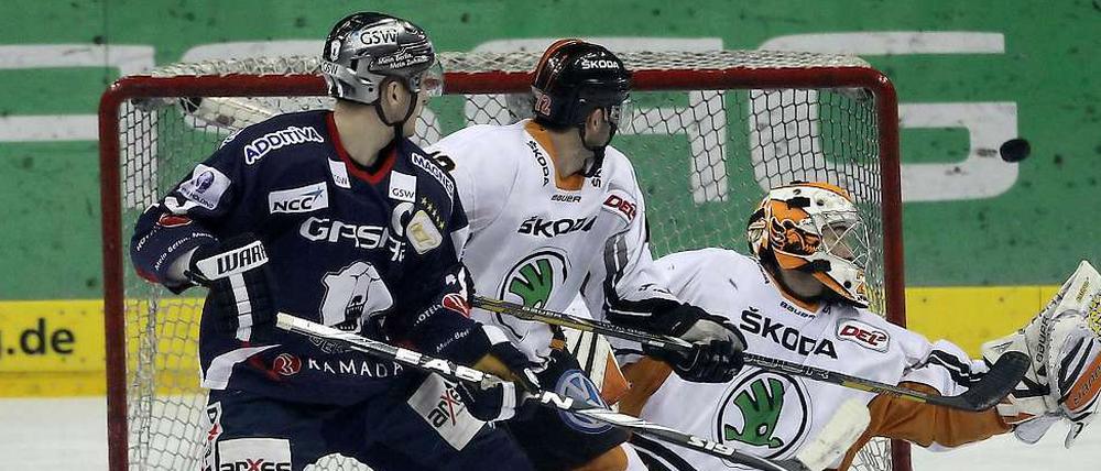 Im Vorbeiflug. André Rankel (l.) schaut gemeinsam mit den Wolfsburgern Armin Wurm und Torwart Sebastian Vogl dem Puck hinterher. Anders als bei seinem Treffer zum 1:0 kann der Eisbären-Stürmer in dieser Szene nicht jubeln.