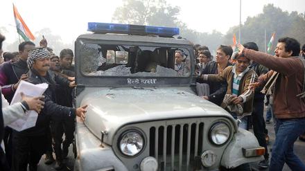 Indische Demonstranten zerstören ein Polizeiauto in Neu-Delhi.