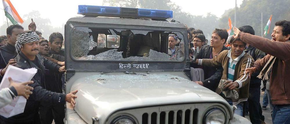 Indische Demonstranten zerstören ein Polizeiauto in Neu-Delhi.