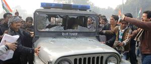 Indische Demonstranten zerstören ein Polizeiauto in Neu-Delhi.