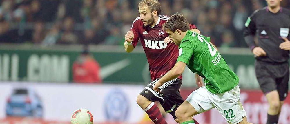 Dem Ball hinterher, am Ball vorbei. Nürnbergs Pinola und Bremens Sokratis im Zweikampf.