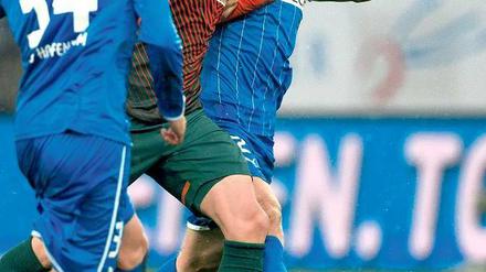 Ab durch die Mitte. Der Bremer Lukas Schmitz setzt sich gegen Hoffenheims Andreas Beck durch. Foto: dpa