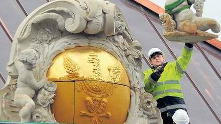 Schwer vergoldet. Am Schloss wurden neue Fassadenteile montiert. Foto: dpa/Settnik