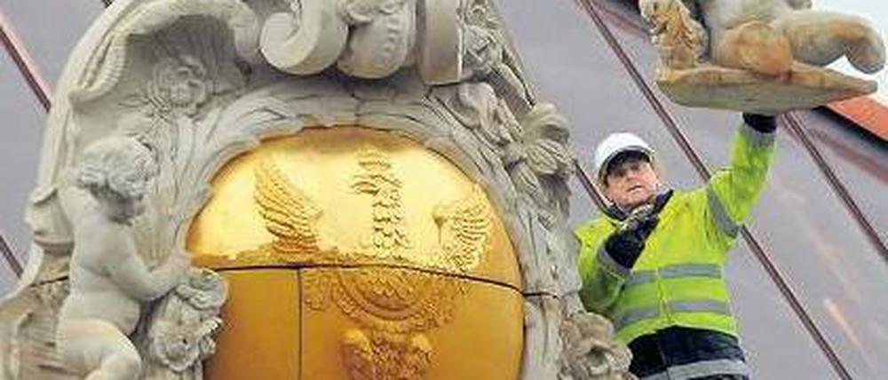 Schwer vergoldet. Am Schloss wurden neue Fassadenteile montiert. Foto: dpa/Settnik