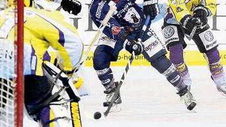 Puck am Stock. Travis Mulock (blaues Trikot) gelang im ersten Drittel der wichtige Anschlusstreffer für die Eisbären.Foto: Thiemo Napierski