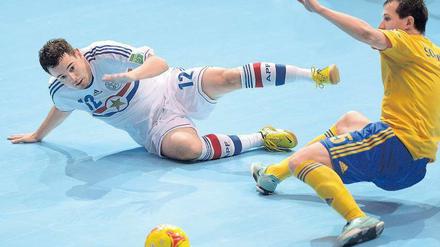 Grätschen auf Gummi. Die WM-Teams müssen auf kleinere Hallen ausweichen, hier kämpfen Paraguays Marcos Benitez (l.) und der Ukrainer Dimitrij Sorokin um den Ball. Foto: AFP