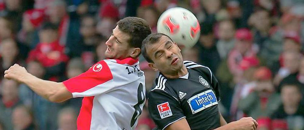 Kopf an Kopf. Berlins Markus Karl (links) und Aalens Cidimar kaempfen um den Ball.