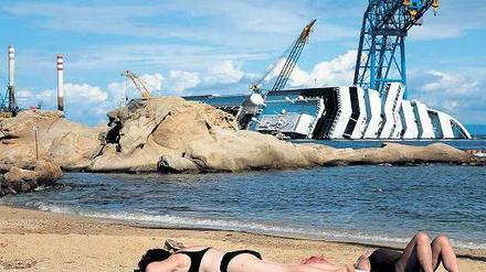 Ungewöhnliche Strandkulisse. Das Wrack der Costa Concordia vor der italienischen Insel Giglio wird derzeit unter Wasser stabilisiert, damit es beim späteren Aufrichten und Abschleppen nicht weiter in die Tiefe des Meeres abrutschen kann. 