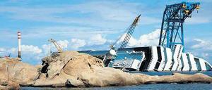 Ungewöhnliche Strandkulisse. Das Wrack der Costa Concordia vor der italienischen Insel Giglio wird derzeit unter Wasser stabilisiert, damit es beim späteren Aufrichten und Abschleppen nicht weiter in die Tiefe des Meeres abrutschen kann. 