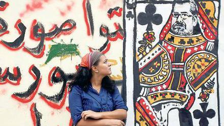 Im Spiel. Eine Frau schaut in der Innenstadt von Kairo auf ein Graffito, das den Präsidenten Mohamed Mursi als Spielkarte zeigt. 